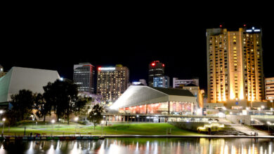 Adelaide Festival Centre at night, the modernist building lit and reflecting in the Torrens River.