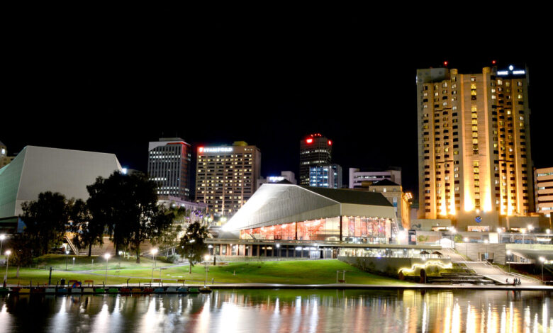 Adelaide Festival Centre at night, the modernist building lit and reflecting in the Torrens River.